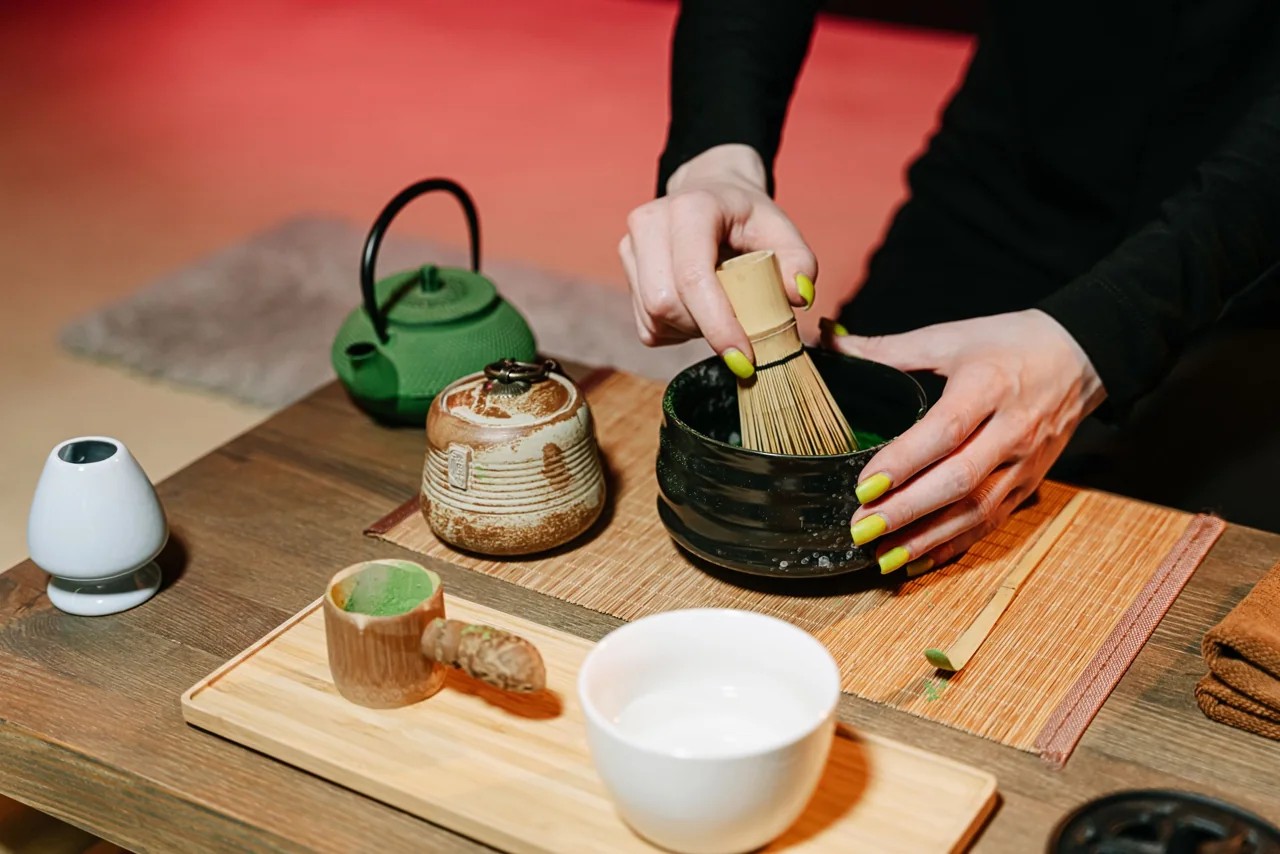 Mãos preparando matcha no Japão